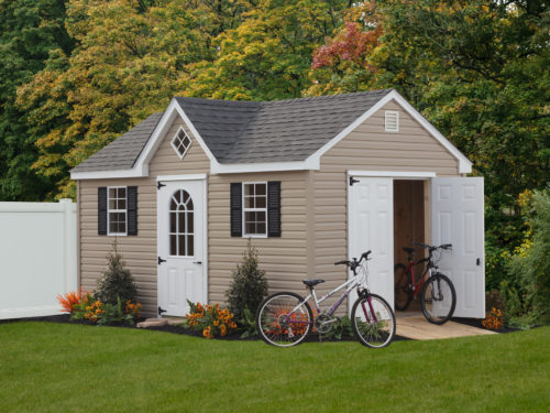 a frame dormer shed with white doors and bikes