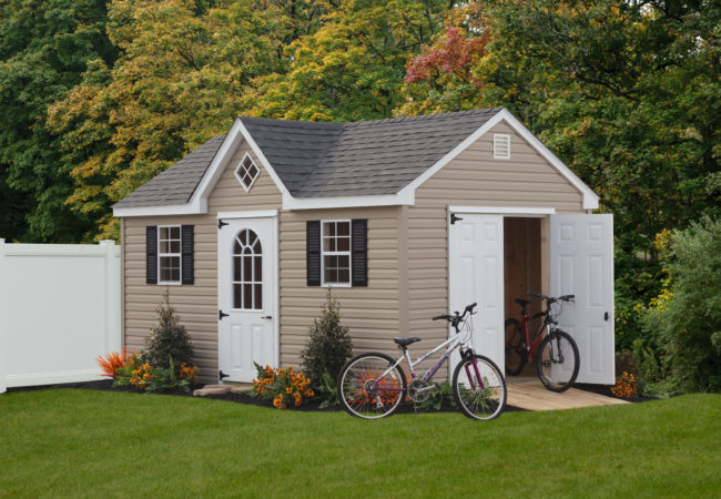 a frame dormer shed with white doors and bikes