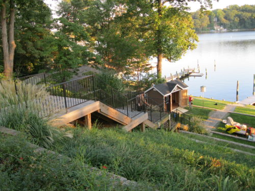 a frame dormer shed sitting next to lake