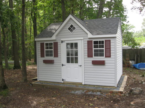a frame dormer shed surrounded by trees