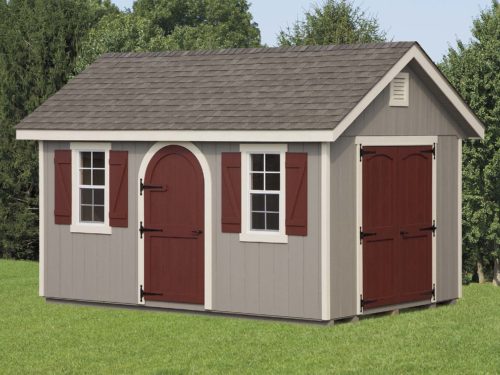 grey classic cottage shed with maroon doors in front of trees