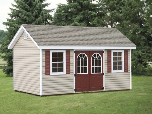 tan classic cottage shed with maroon doors and asphalt shingles