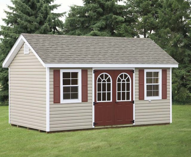 tan classic cottage shed with maroon doors and asphalt shingles