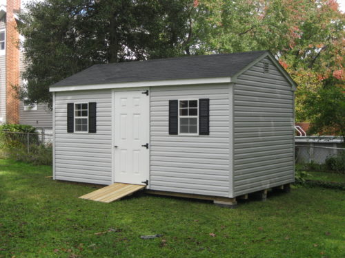 grey cottage shed with single white door