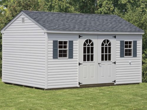 grey cottage shed sitting on lawn in backyard