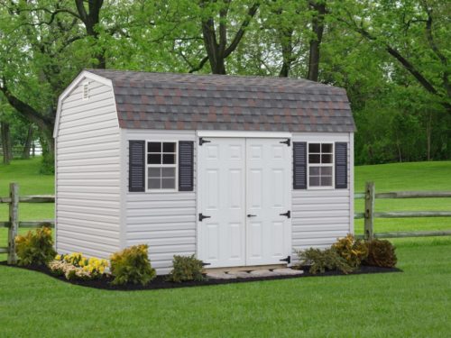 backyard dutch barn shed with white double doors sitting in front of fence