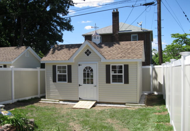 classic a frame dormer shed with white door in backyard