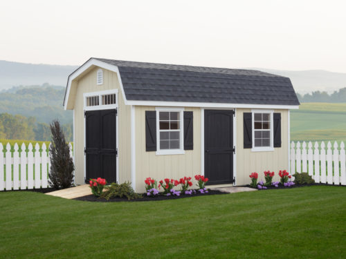 classic dutch barn shed in front of white picket fence