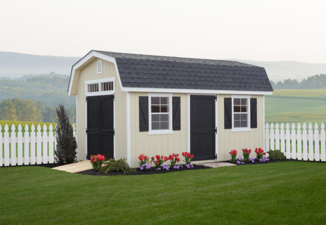 classic dutch barn shed in front of white picket fence