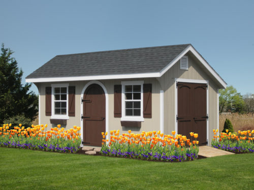 classic quaker shed with brown doors and flowers in front