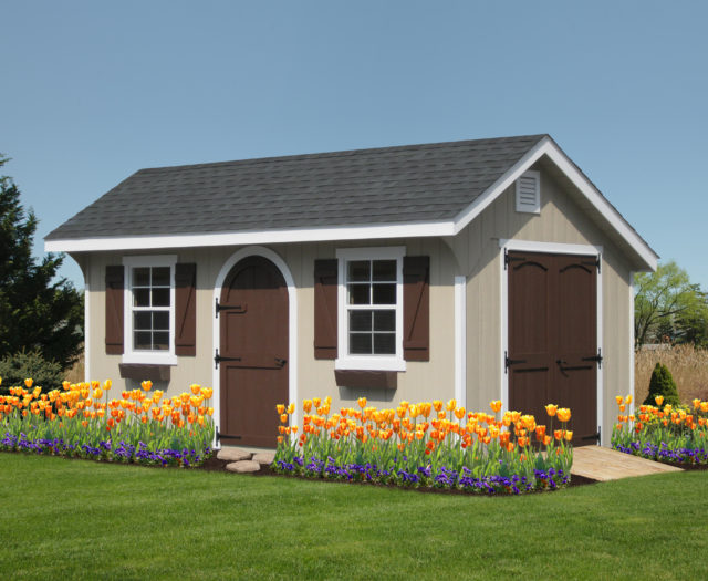 classic quaker shed with brown doors and flowers in front