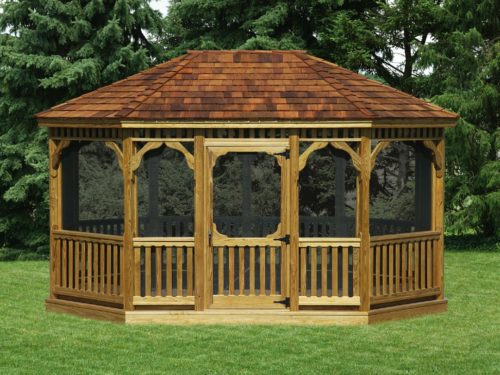 large wood gazebo sitting in front of pine trees