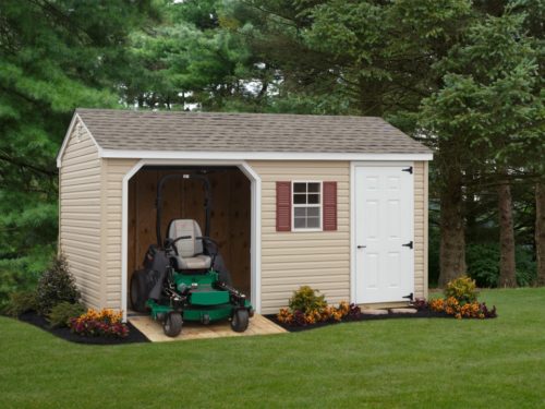 tan 7 cottage garage with green lawnmower