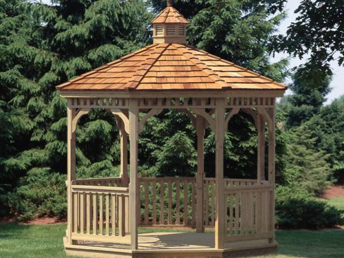 wood gazebo sitting in front of pine trees