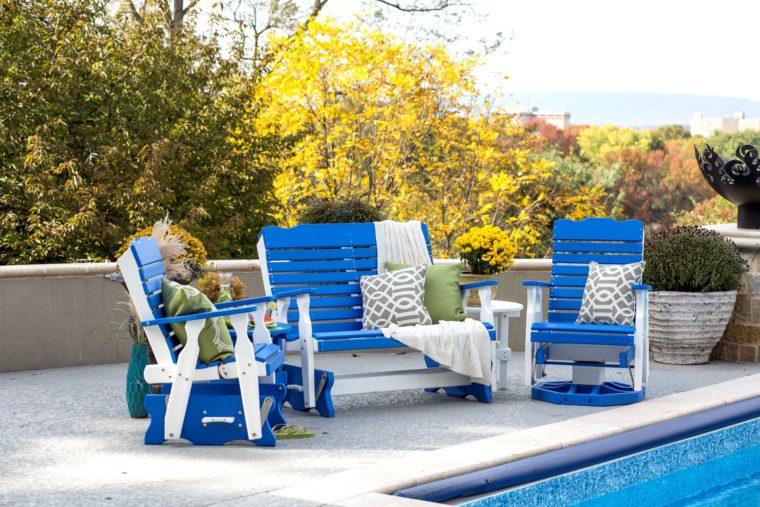 blue and white lawn furniture sitting by pool