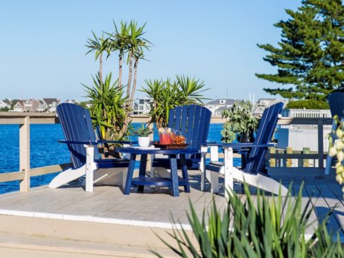 blue outdoor furniture sitting in front of bay on elevated synthetic deck