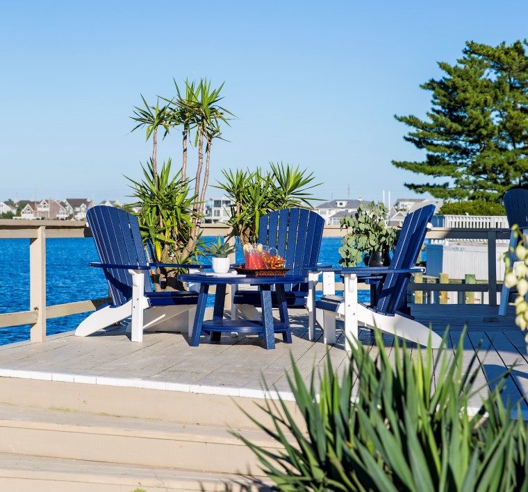 blue outdoor furniture sitting in front of bay on elevated synthetic deck