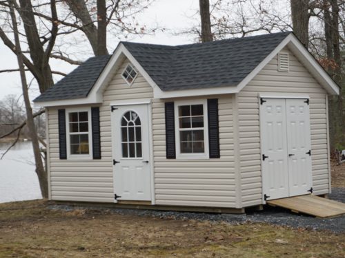 tan classic a frame dormer shed in front of lake