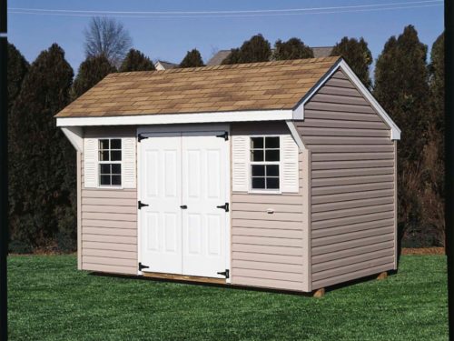 tan quaker shed with white door in backyard