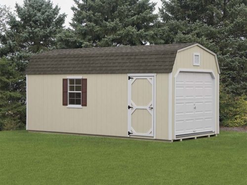 tan dutch barn garage with white door and asphalt shingles sitting green grass