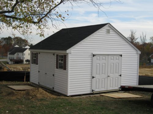 white cape shed with asphalt shingles and white doors