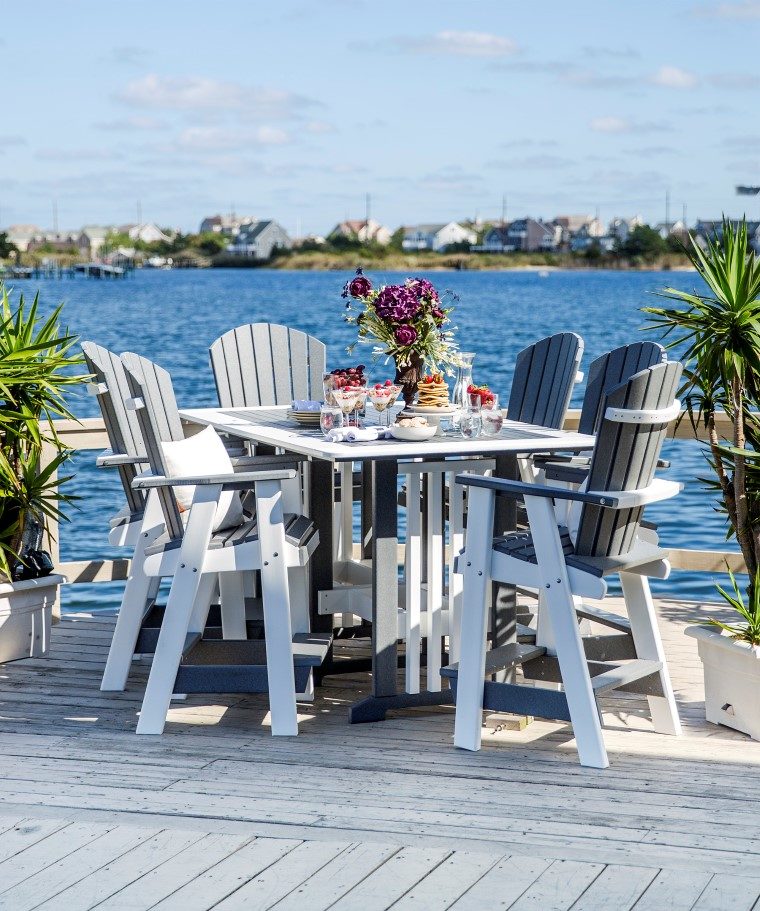 white outdoor furniture set sitting on deck overlooking the bay