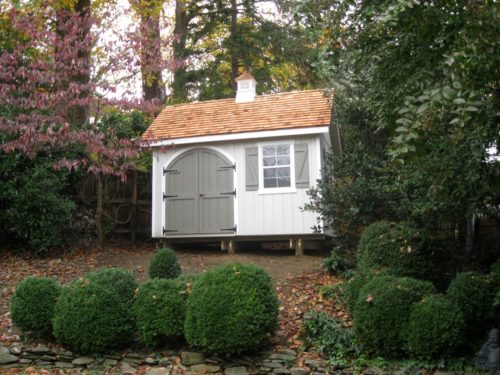 custom classic cottage she in between trees and shrubs