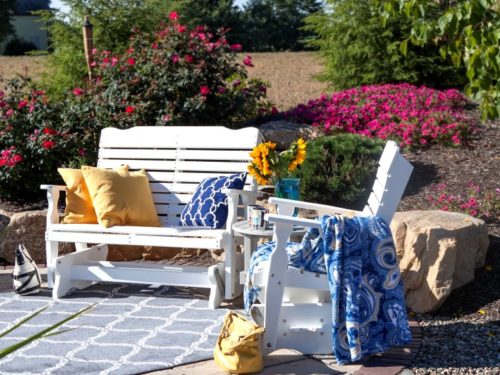 lawn furniture in backyard with pillows and blanket