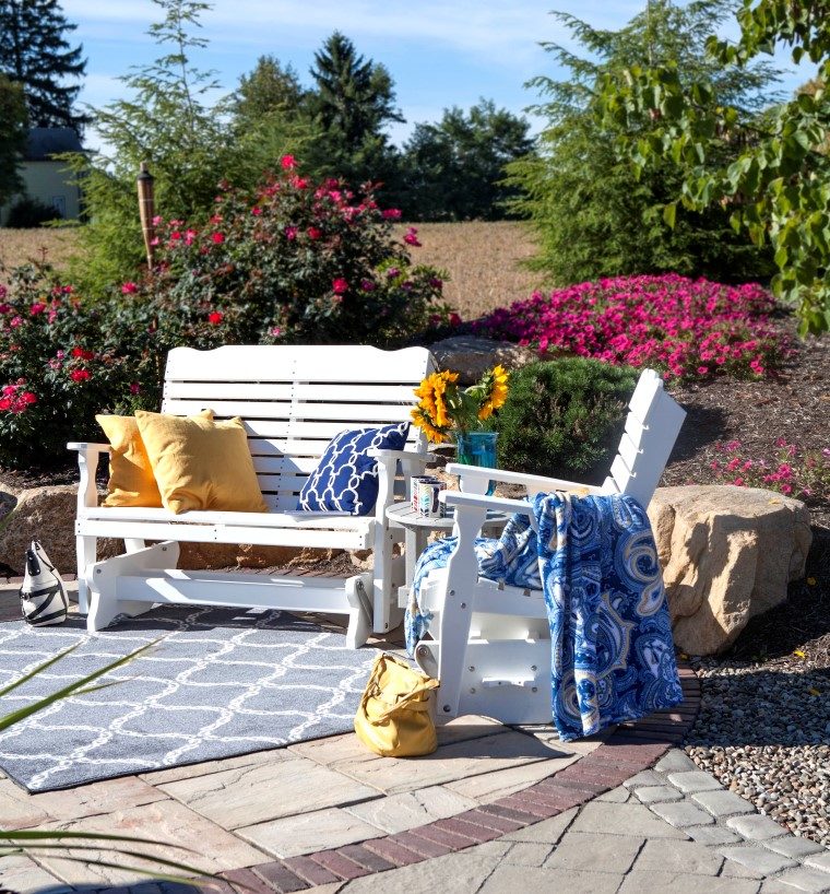 lawn furniture in backyard with pillows and blanket