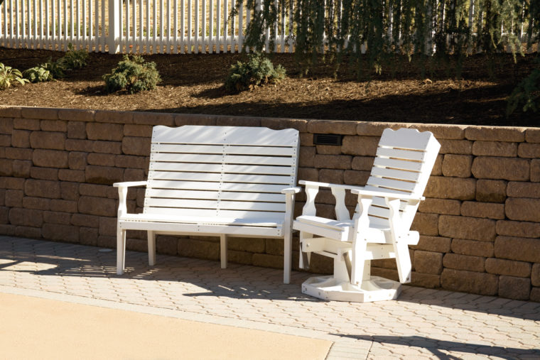 white outdoor furniture in front of retaining wall