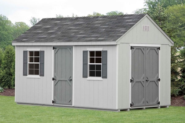 light grey backyard cape shed sitting in front of trees