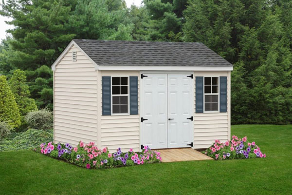 cape shed in backyard with flowers around side and front